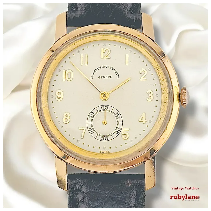 Vintage watch with gold case and black strap on a white background, featuring the brand 'Rubylane'.