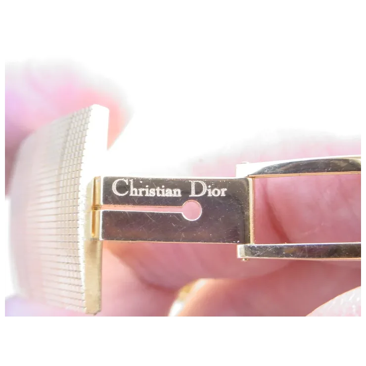 Eyelash extension tool with Christian Dior branding on a blurred background