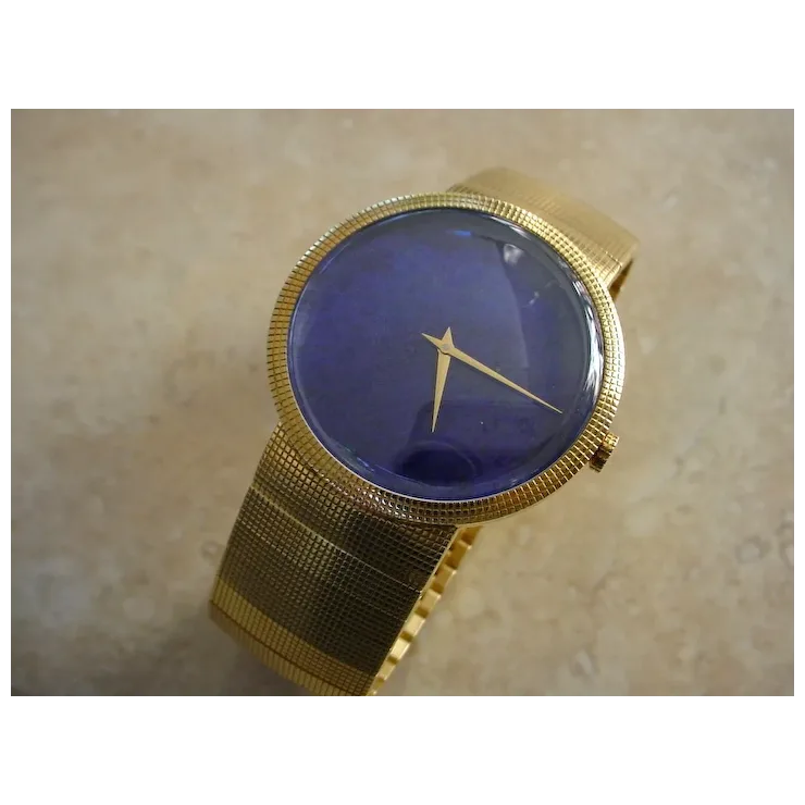 Gold wristwatch with a blue face on a beige background