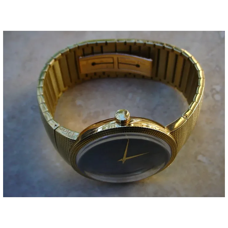 Gold wristwatch with a dark face on a textured surface