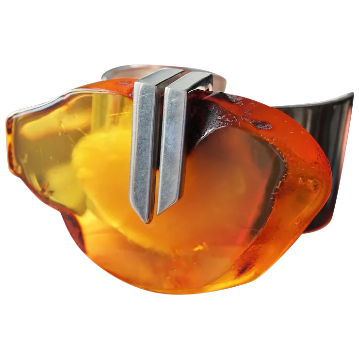 Amber-colored glass object with a metallic accent on a white background
