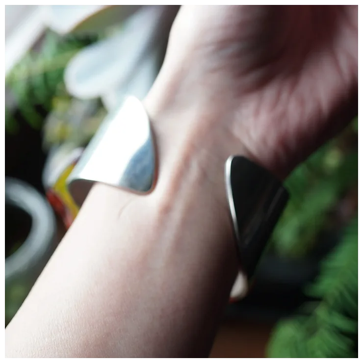 Close-up of a hand wearing a silver ring with a blurred background