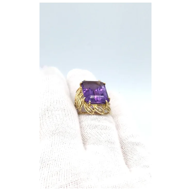 Gold ring with a purple gemstone on a white background