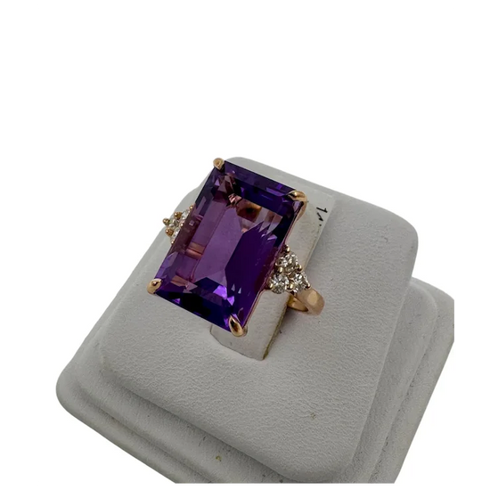 Ring with purple gemstone on a gray stand