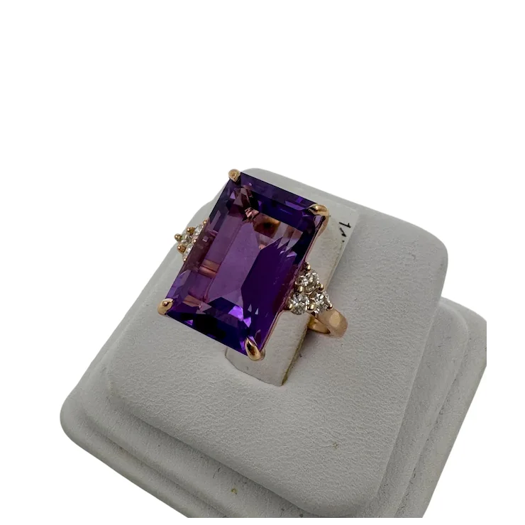 Ring with purple gemstone on a gray stand