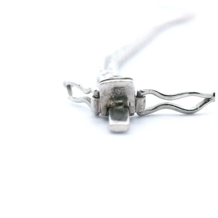 Metallic clip with a white cord on a white background