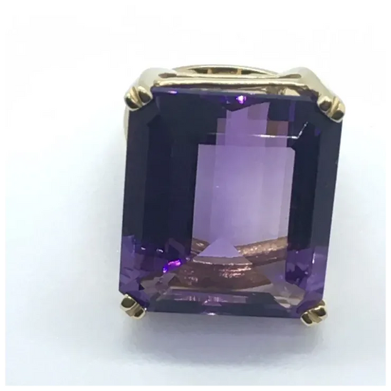 Gold ring with a large purple gemstone on a white background