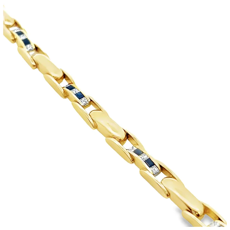Gold bracelet with embedded blue stones on a white background