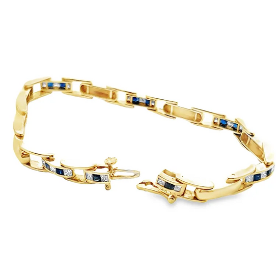 Gold bracelet with embedded blue and white stones on a white background