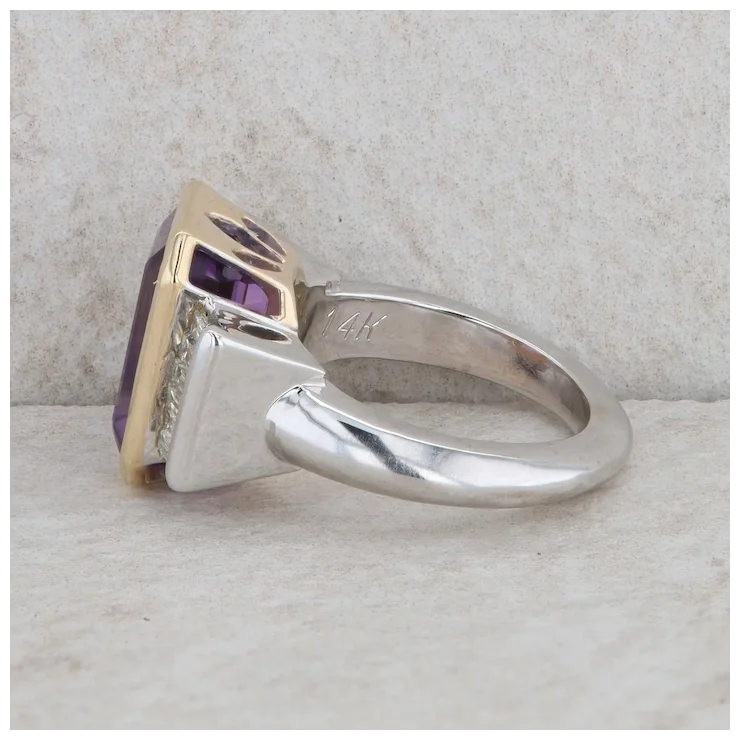 Silver ring with a purple gemstone on a textured surface