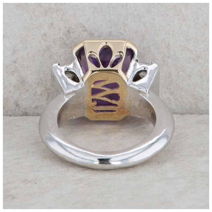 Ring with gold and silver design on a textured surface
