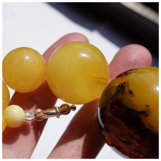 Close-up of a yellow beaded bracelet held between fingers
