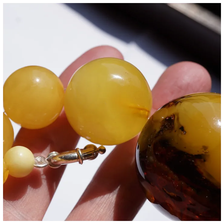Close-up of a yellow beaded bracelet held between fingers