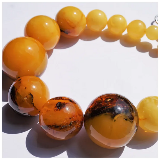 Close-up of a bracelet with amber beads on a white background