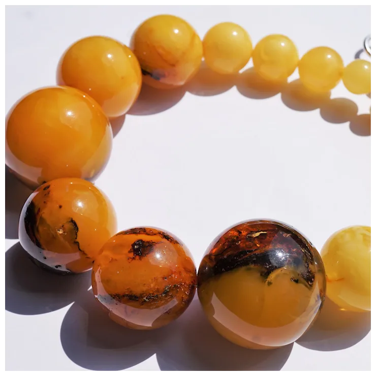 Close-up of a bracelet with amber beads on a white background