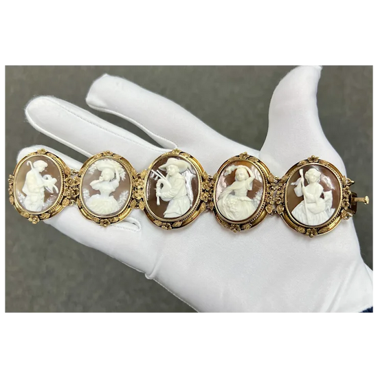 Vintage-style bracelet with cameo stones on a mannequin hand against a neutral background