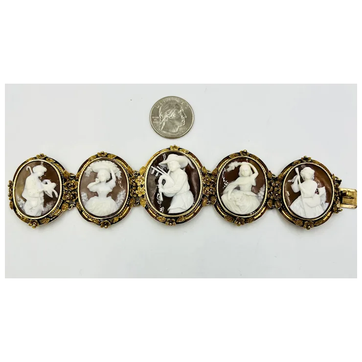 Bracelet with cameo stones next to a quarter for scale on a white background