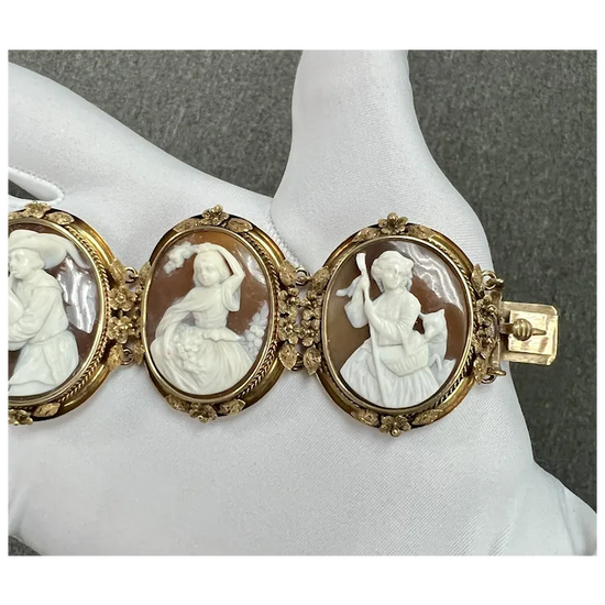 Vintage-style bracelet with three cameo stones on a mannequin arm against a gray background