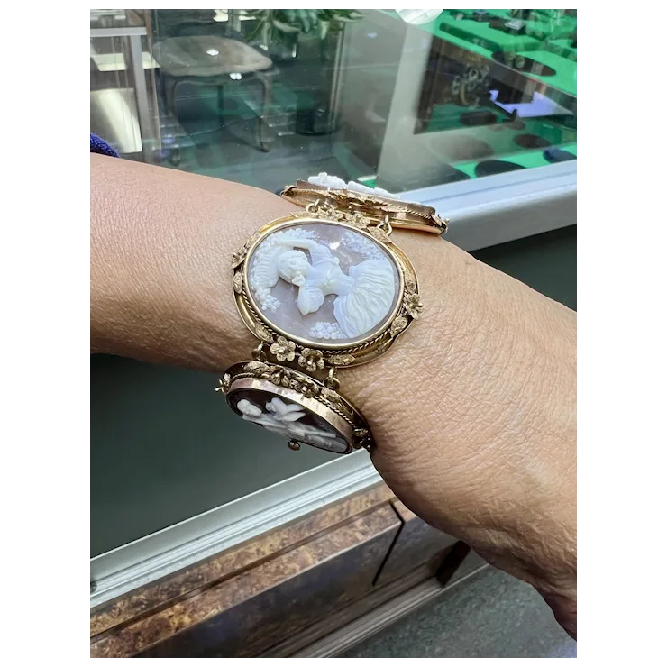 Gold wristwatch with intricate design worn on a wrist, blurred background