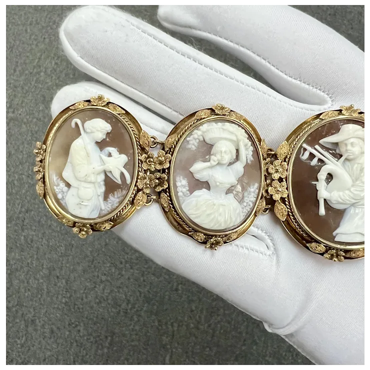 Three ornate cameos on a white surface with a gray background