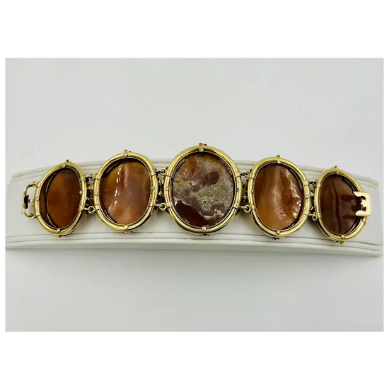 Gold bracelet with five brown oval stones on a white background