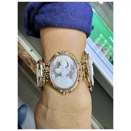 Gold bracelet with a cameo design on a wrist