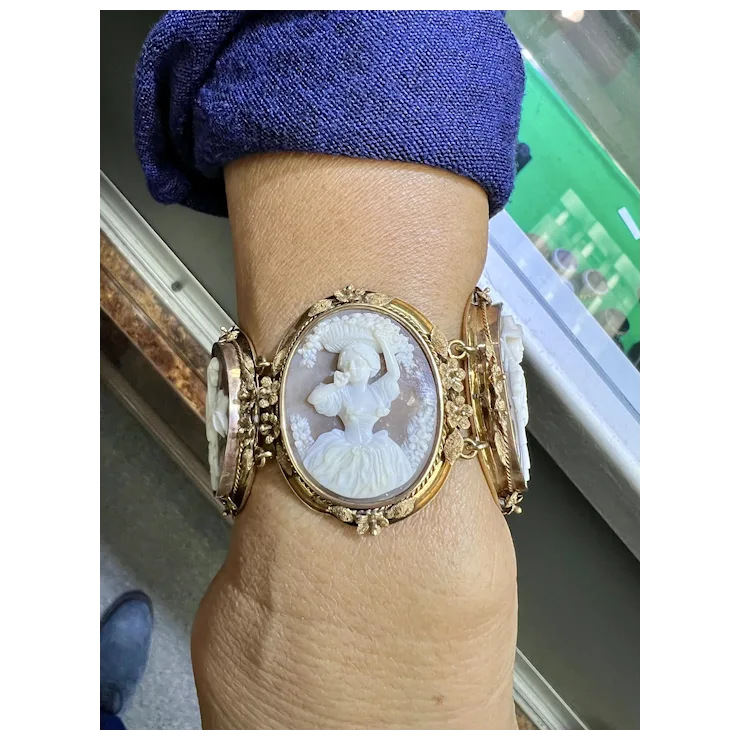 Gold bracelet with a cameo design on a wrist