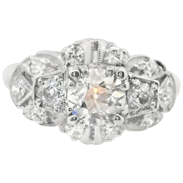 Silver ring with a large central gemstone and smaller stones on a white background