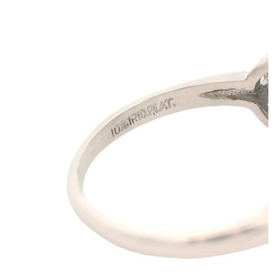 Close-up of a silver ring with '10K W.R.D. PLAT.' engraving on a white background