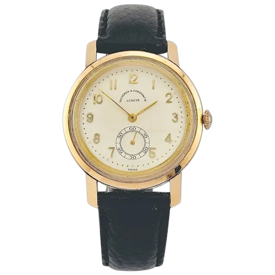 Gold watch with black leather strap on a white background