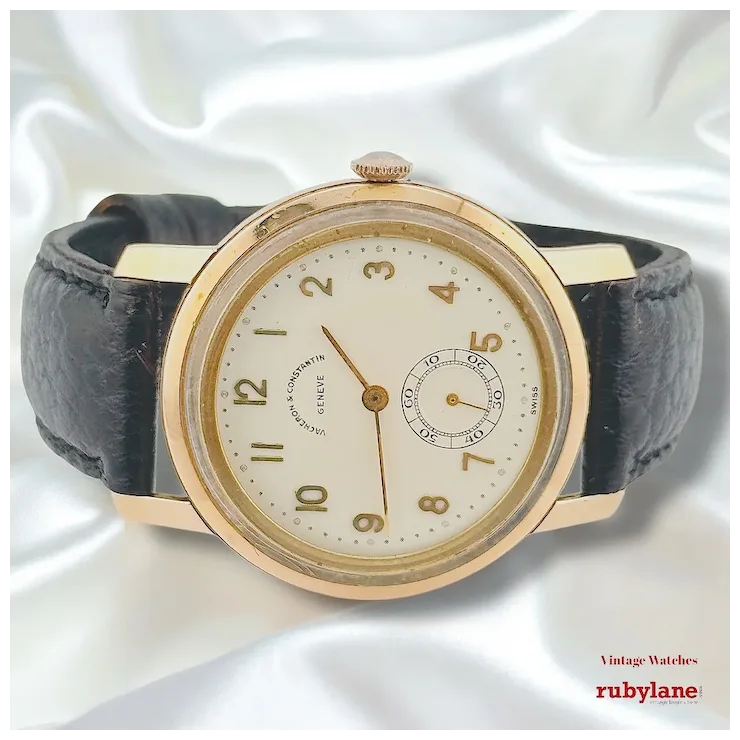 Vintage watch with black leather strap and gold case on a white background, featuring the Ruby Lane logo.