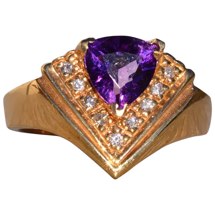 Gold ring with a purple gemstone and smaller diamonds on a white background