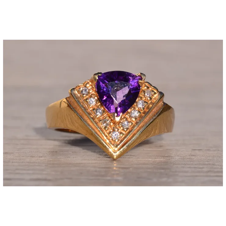 Gold ring with a purple gemstone on a wooden surface