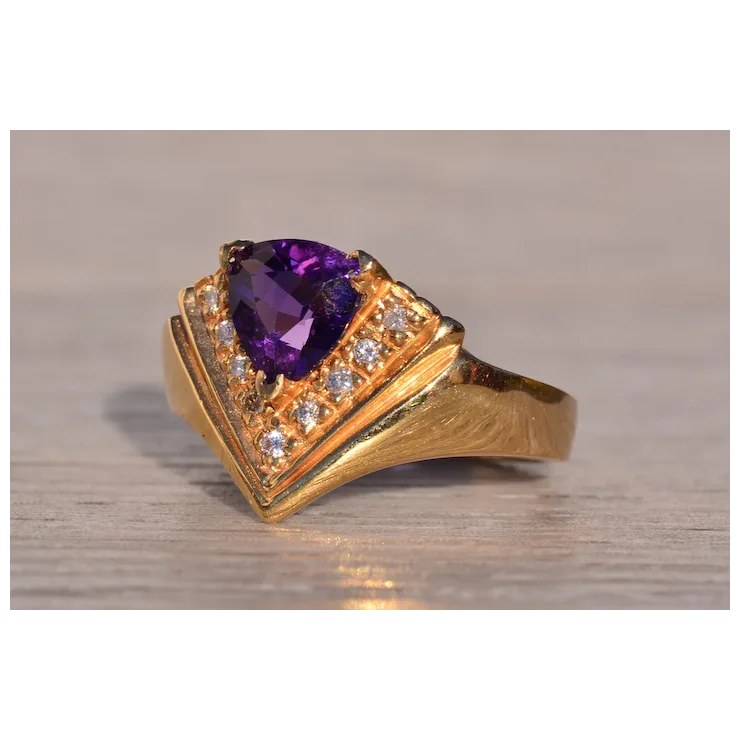 Gold ring with a purple gemstone on a wooden surface