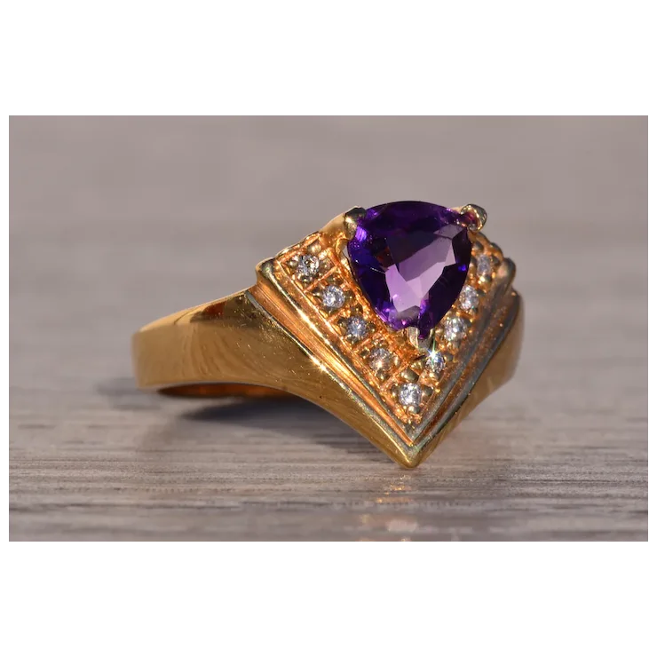 Gold ring with a purple gemstone on a wooden surface