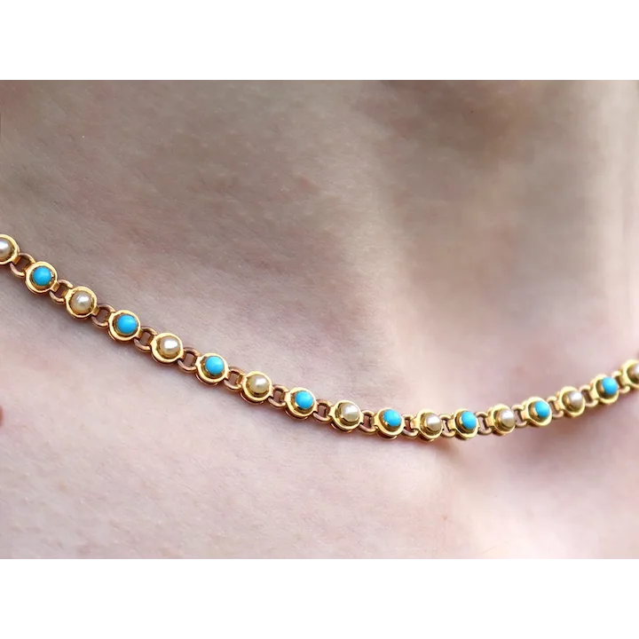 Gold bracelet with turquoise stones on a wrist against a neutral background