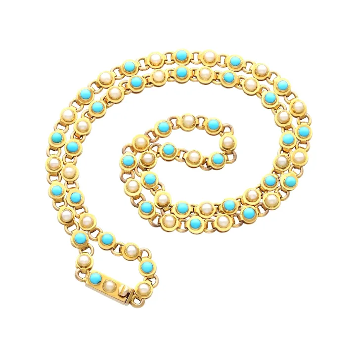 Gold necklace with pearls and turquoise stones on a white background
