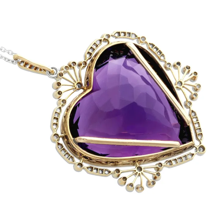 Purple heart-shaped gemstone pendant with gold and silver accents on a white background