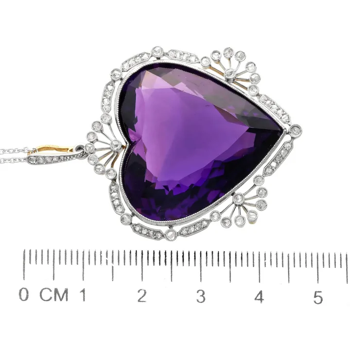 Purple teardrop-shaped gemstone necklace with silver and gold accents on a white background.