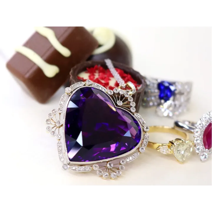 Jewelry set with a purple heart-shaped gemstone on a white background
