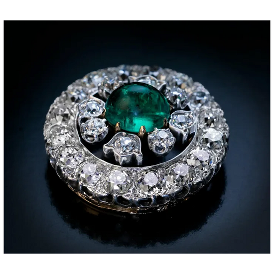 Jewelry with a green gemstone and diamond accents on a dark background