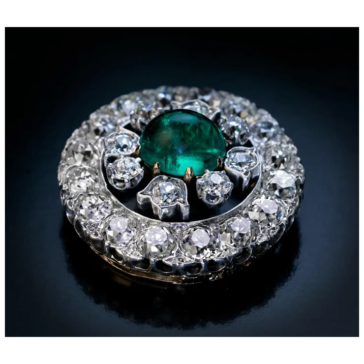 Jewelry with a green gemstone and diamond accents on a dark background