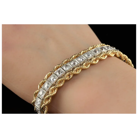 Gold bracelet with diamond accents on a wrist against a neutral background