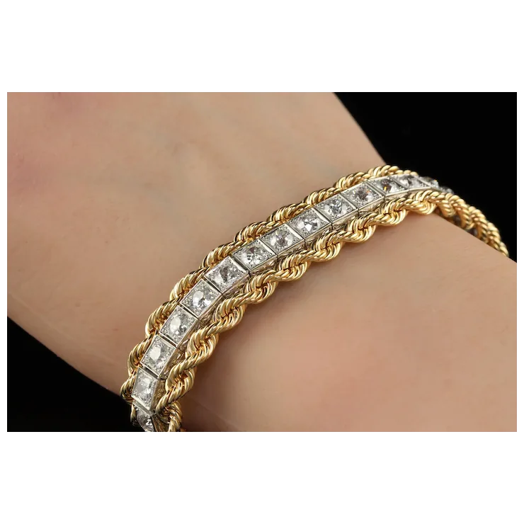 Gold bracelet with diamond accents on a wrist against a neutral background