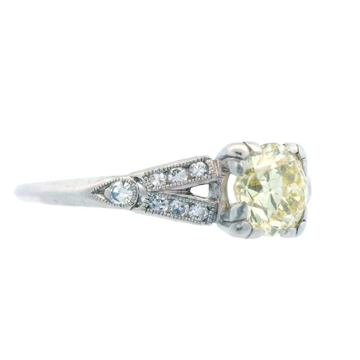 Diamond ring with a yellow gemstone on a white background