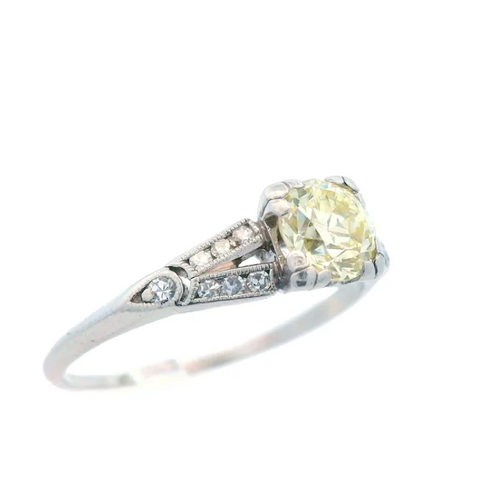 Ring with a yellow gemstone and diamond accents on a white background