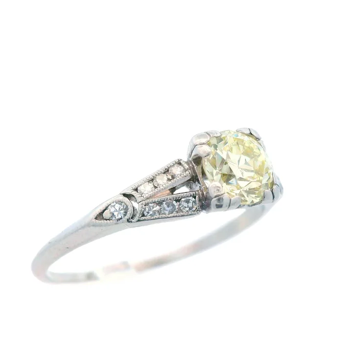 Ring with a yellow gemstone and diamond accents on a white background