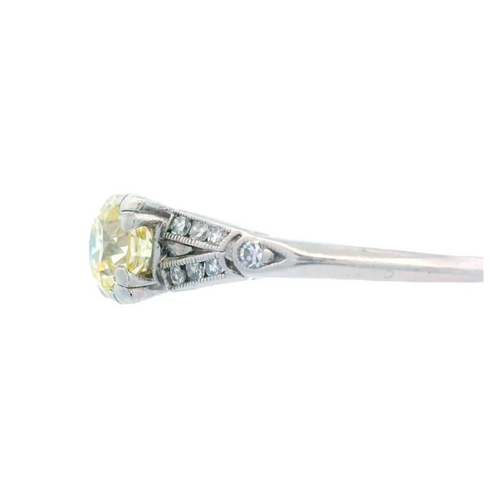 Diamond ring with a yellow gemstone on a white background