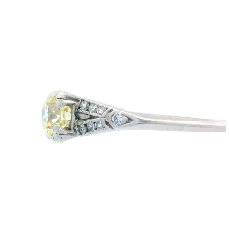 Diamond ring with a yellow gemstone on a white background