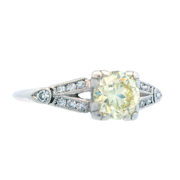 Diamond ring with a yellow gemstone on a white background